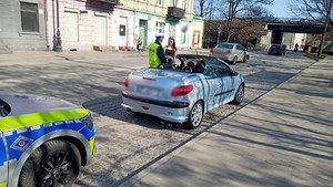 Policjant podczas kontroli wręczający kwiaty.