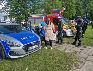 Policjanci podczas pikniku wraz z odwiedzającymi policyjne stoisko.