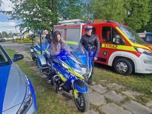 Policjanci podczas pikniku wraz z odwiedzającymi policyjne stoisko.
