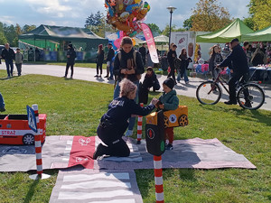 Policjanci podczas pikniku wraz z odwiedzającymi policyjne stoisko.