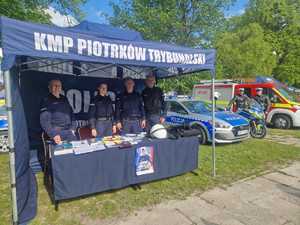 Policjanci podczas pikniku wraz z odwiedzającymi policyjne stoisko.