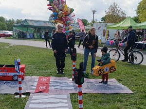 Policjanci podczas pikniku wraz z odwiedzającymi policyjne stoisko.