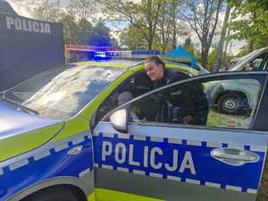 Policjanci podczas pikniku wraz z odwiedzającymi policyjne stoisko.