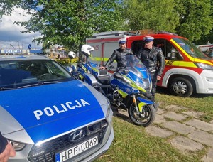 Policjanci podczas pikniku wraz z odwiedzającymi policyjne stoisko.