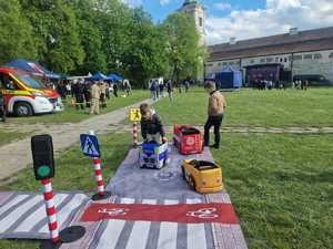 Policjanci podczas pikniku wraz z odwiedzającymi policyjne stoisko.