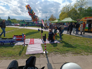Policjanci podczas pikniku wraz z odwiedzającymi policyjne stoisko.