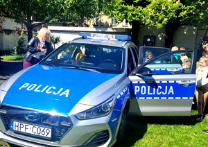 Dzieci przy policyjnym radiowozie.