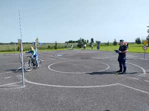 Policjant wraz z dziećmi podczas egzaminu na kartę rowerową.
