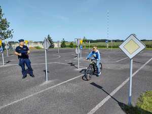 Policjant wraz z dziećmi podczas egzaminu na kartę rowerową.