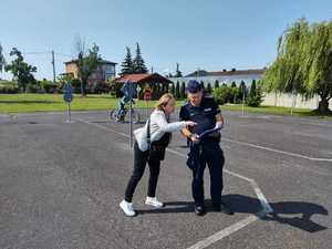 Policjant wraz z dziećmi podczas egzaminu na kartę rowerową.