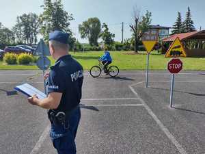 Policjant wraz z dziećmi podczas egzaminu na kartę rowerową.