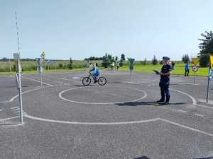 Policjant wraz z dziećmi podczas egzaminu na kartę rowerową.