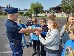 Policjant wraz z dziećmi podczas egzaminu na kartę rowerową.