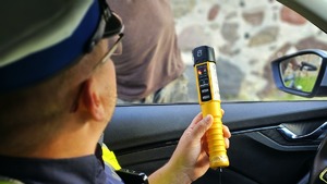 Policjanci i radiowóz policyjny podczas kontroli.