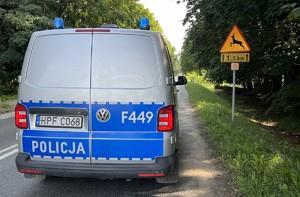 Policyjny radiowóz obok znaku &quot;uwaga dzikie zwierzęta&quot;.