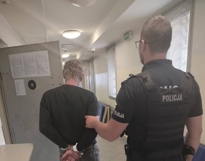 Policjant z zatrzymanym, przy policyjnej celi.