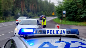 Policjant kontroluje stan trzeźwości kierowcy pojazdu.