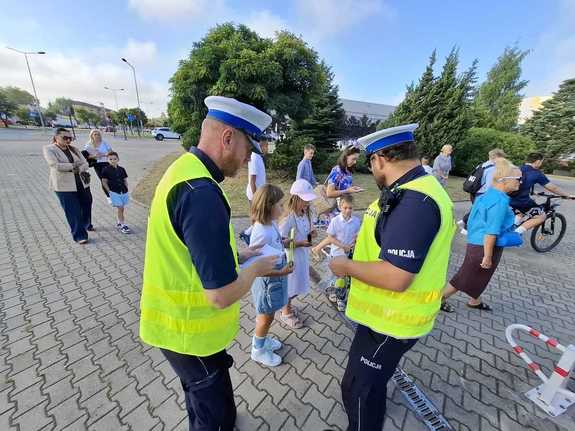 Policjanci podczas przekazywania elementów odblaskowych.