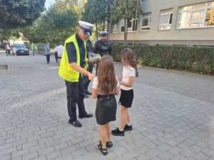 Policjanci podczas przekazywania elementów odblaskowych.