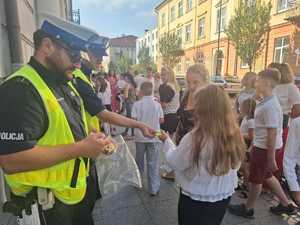 Policjanci podczas przekazywania elementów odblaskowych.