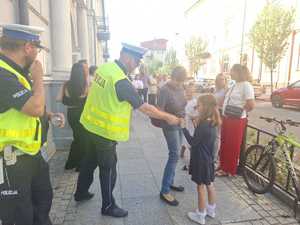 Policjanci podczas przekazywania elementów odblaskowych.