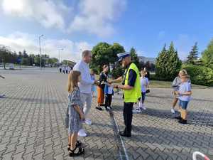 Policjanci podczas przekazywania elementów odblaskowych.