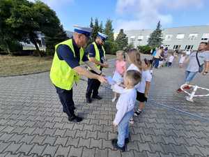 Policjanci podczas przekazywania elementów odblaskowych.