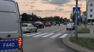 Policjant i radiowóz policyjny na miejscu zdarzenia.
