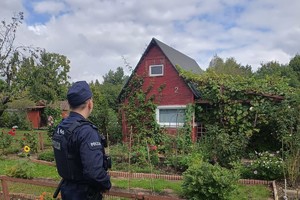 Policjant podczas kontroli terenów ogródków działkowych.