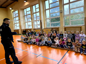 Policjant wraz z dziećmi podczas prelekcji w szkole podstawowej.