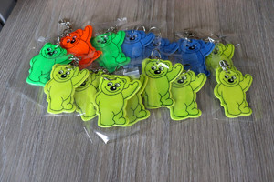 Elementy odblaskowe w kształcie misia w różnych kolorach.