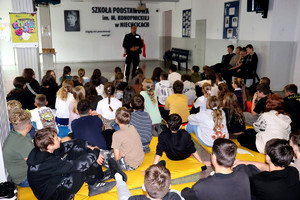 Policjant wraz z uczniami podczas prelekcji w szkole podstawowej.