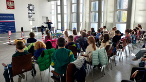 Policjantka wraz z dziećmi podczas prelekcji w komendzie.