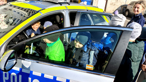 Policjantka wraz z dziećmi podczas prelekcji na dziedzińcu komendy.