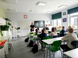 Policjant wraz z uczniami podczas prelekcji.