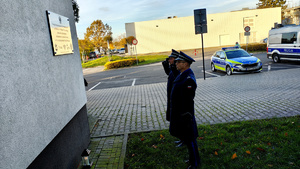 Komendant Miejski Policji w Piotrkowie Trybunalskim oraz I Zastępca Komendanta Miejskiego Policji w Piotrkowie Trybunalskim oddający  hołd przy tablicy pamiątkowej.