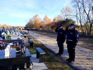 Komendant Komisariatu w Grabicy oraz  Kierownik Posterunku Policji w Rozprzy oddający hołd przy grobie.