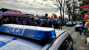 Dach radiowozu oraz policjant przy nekropolii.