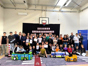 Policjanci oraz przedstawiciel Służby Więziennej z dziećmi podczas spotkania profilaktycznego.