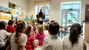 Policjant wraz z dziećmi podczas pogadanki.