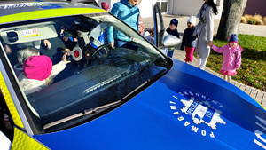 Przedszkolaki wsiadające do radiowozu.