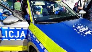 Przedszkolaki wsiadające do radiowozu.