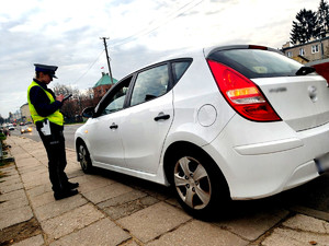 Policjantka stojąca przy aucie podczas kontroli drogowej.