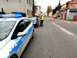 Policjantka stojąca przy aucie podczas kontroli drogowej.