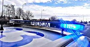 Dach radiowozu z włączonymi światłami błyskowymi.