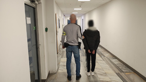 Policjant trzymający zatrzymaną.