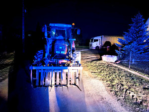 Ciągnik rolniczy zaparkowany na środku drogi.