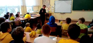 Policjantka podczas prelekcji wraz z dziećmi.