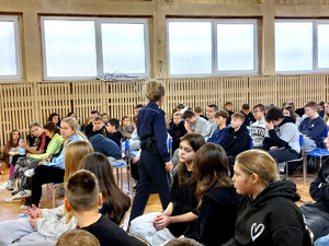 Policjantka wraz z uczniami podczas prelekcji.