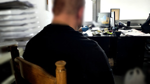 Zatrzymany mężczyzna siedzący w pokoju.